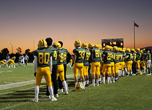 Peoria football team watches game as sun sets